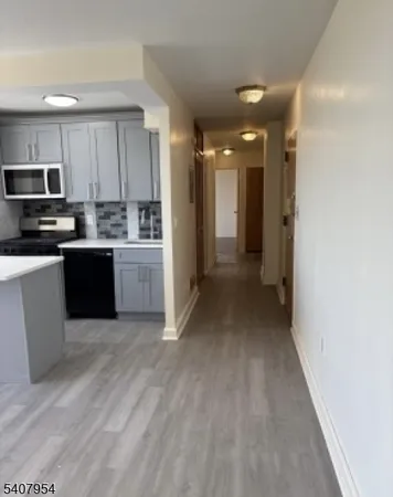 a view of a kitchen with a sink and dishwasher a oven with wooden floor