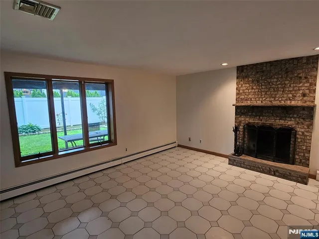 a view of an empty room with a fireplace and a window