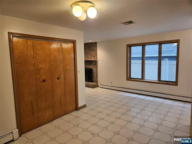 a kitchen with granite countertop a refrigerator and white cabinets
