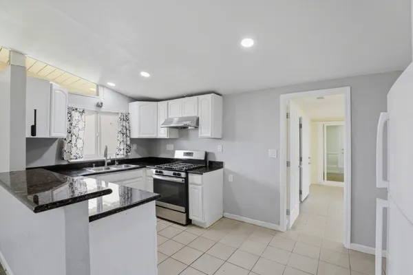 a kitchen with stainless steel appliances granite countertop a stove a sink and a refrigerator