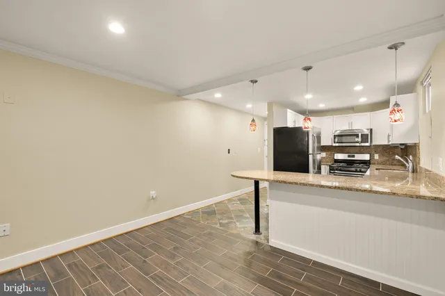 a kitchen with stainless steel appliances a refrigerator and a stove top oven