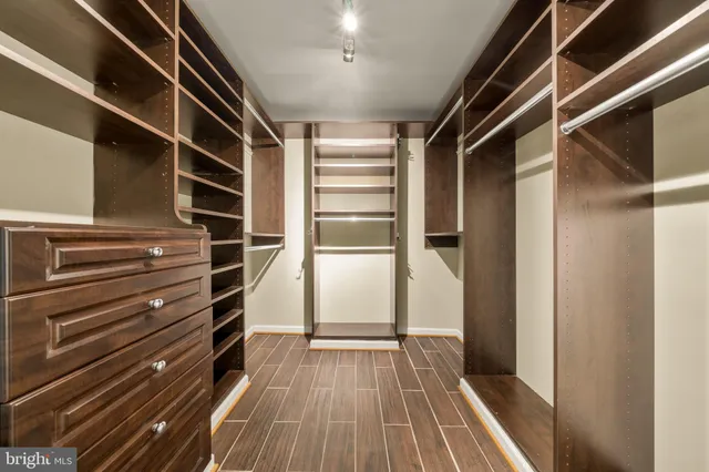 a view of walk in closet with wooden floor