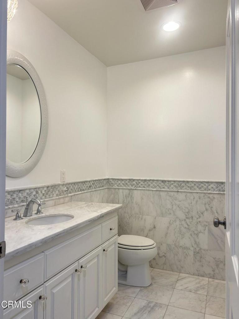 5026 Hook Tree Road La Canada Flintridge, CA 91011 - Photo 20 of 25 a bathroom with a granite countertop toilet a sink and a mirror
