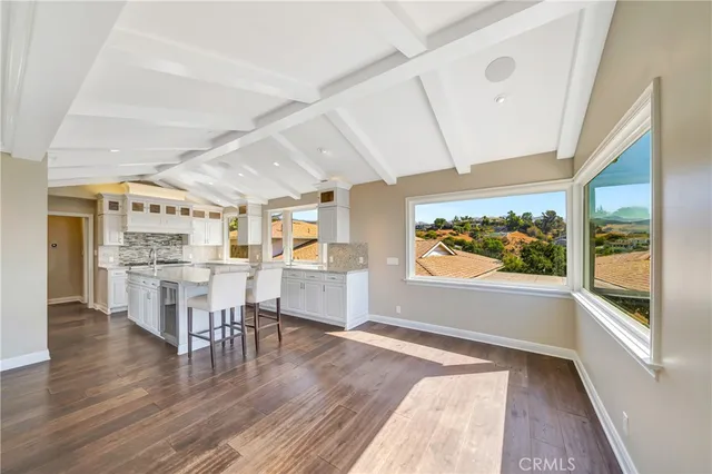 a kitchen with stainless steel appliances white cabinets and wooden floor