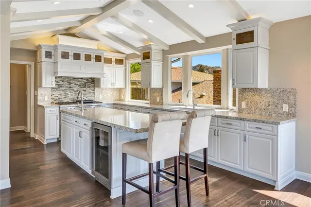 a large hall with stainless steel appliances lots of counter space and breakfast area