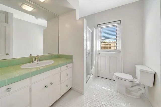 a view of an empty room with a window and a bathroom