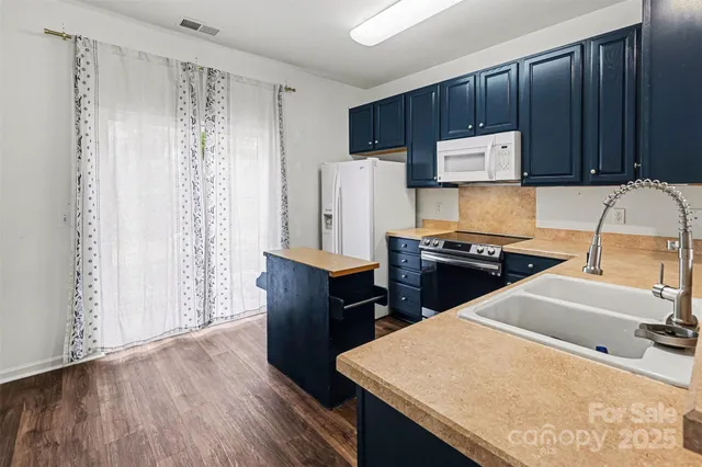 a kitchen with kitchen island sink refrigerator and stove