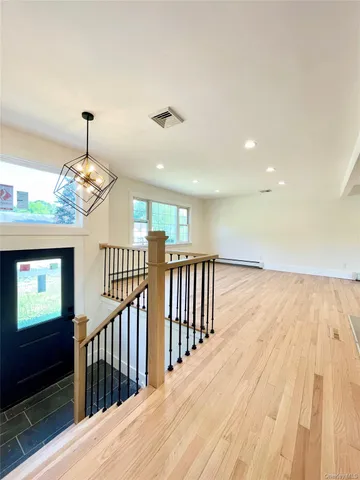 a view of a hallway with wooden floor and windows