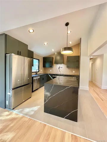 a kitchen with stainless steel appliances granite countertop a sink and a stove