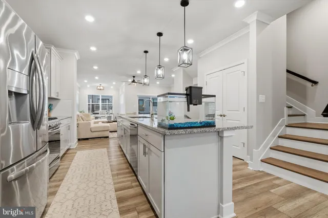 a kitchen with stainless steel appliances kitchen island a white stove top oven and a chandelier
