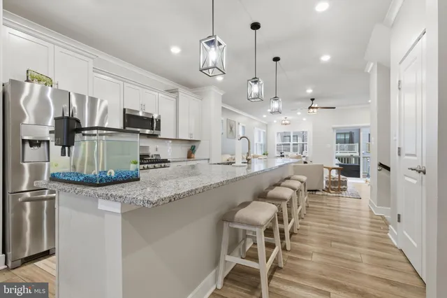 a large kitchen with stainless steel appliances kitchen island granite countertop a large center island attached withe living room