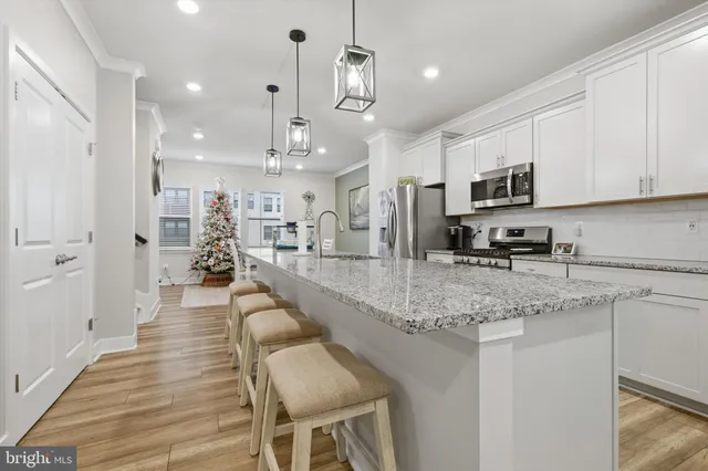 a large white kitchen with lots of counter space a sink and appliances