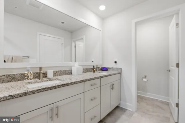 a bathroom with double sink and a mirror
