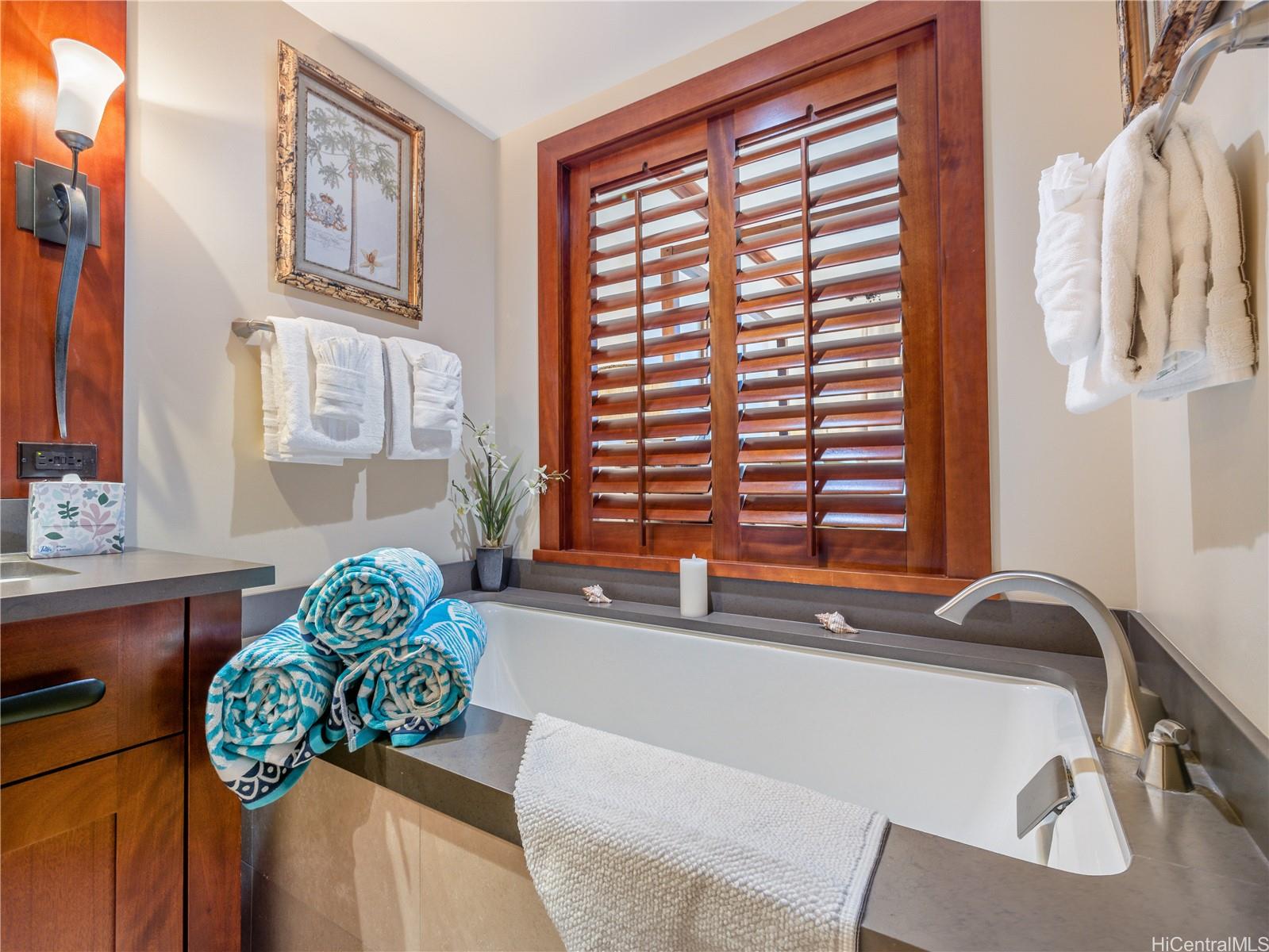 92-104 Waialii Place, Unit O712 Kapolei, HI 96707 - Photo 13 of 25 a bath tub sitting in a bathroom next to a window