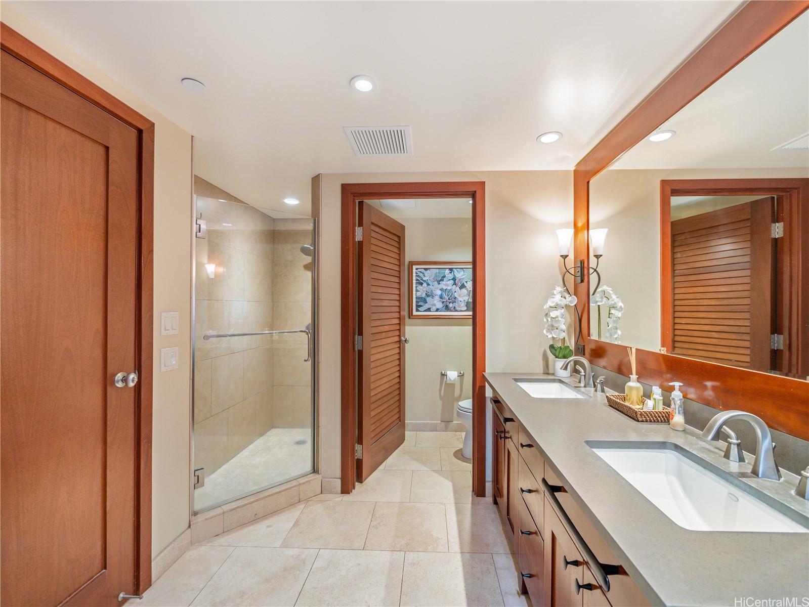 92-104 Waialii Place, Unit O712 Kapolei, HI 96707 - Photo 14 of 25 a bathroom with a double vanity sink a mirror and a shower