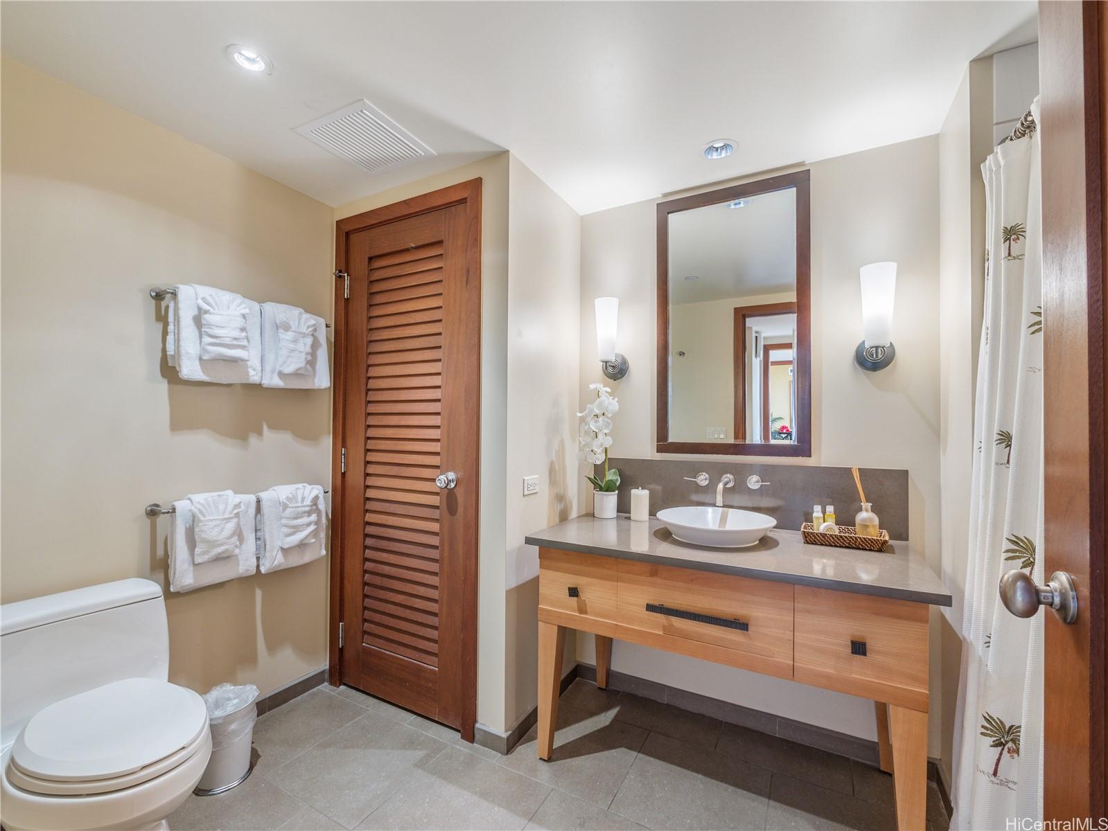 92-104 Waialii Place, Unit O712 Kapolei, HI 96707 - Photo 16 of 25 a bathroom with a sink a toilet and shower curtain