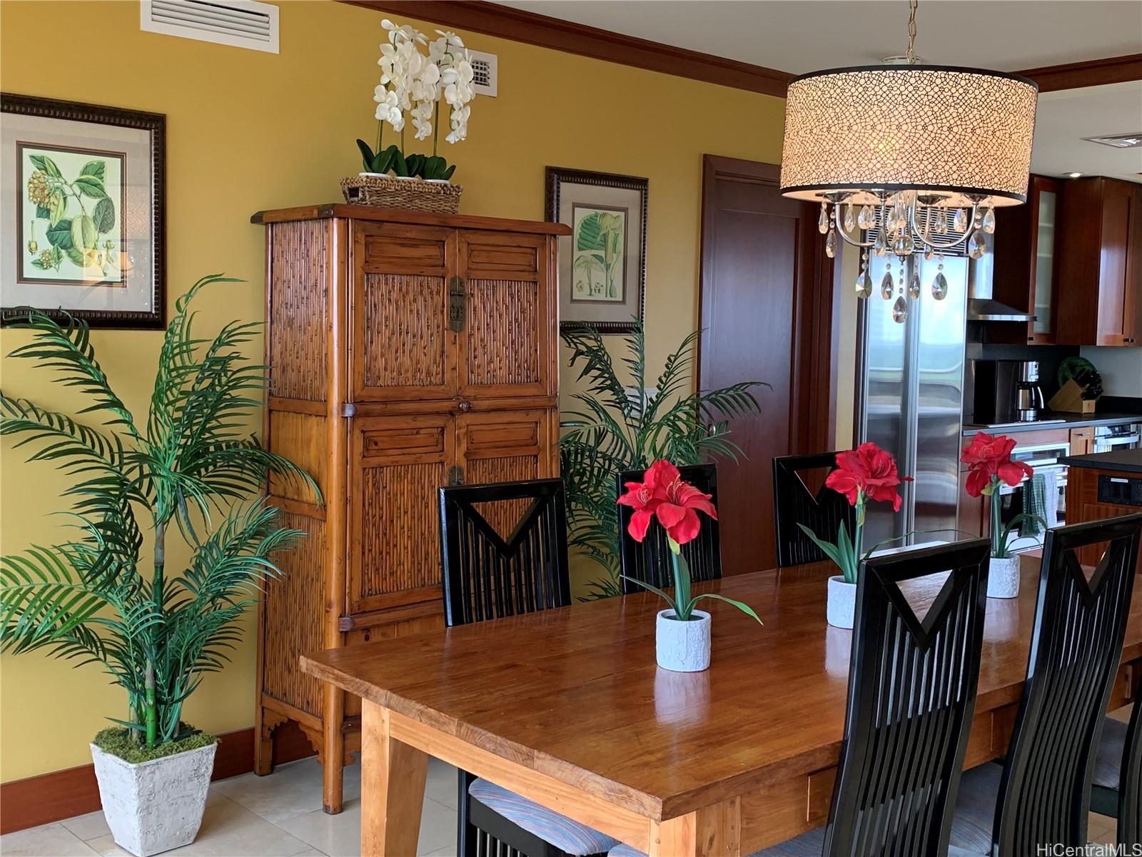 92-104 Waialii Place, Unit O712 Kapolei, HI 96707 - Photo 8 of 25 a dining room with furniture potted plants and wooden floor