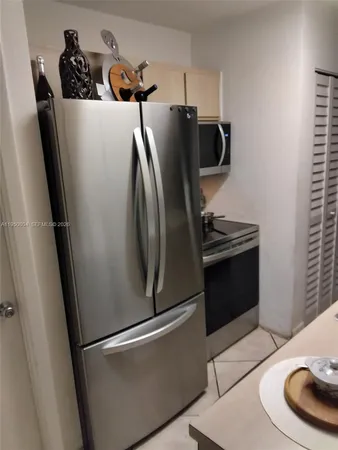 a metallic refrigerator freezer sitting in a kitchen