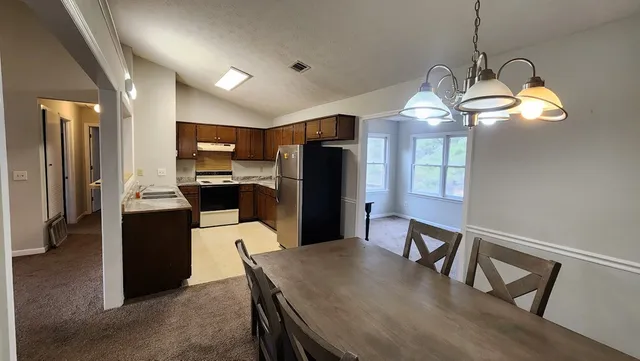 a kitchen with kitchen island a counter top space stainless steel appliances and cabinets
