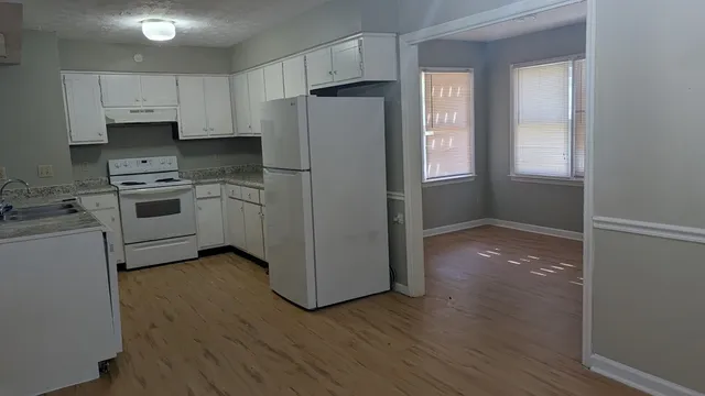 a kitchen with a refrigerator stove and wooden cabinets