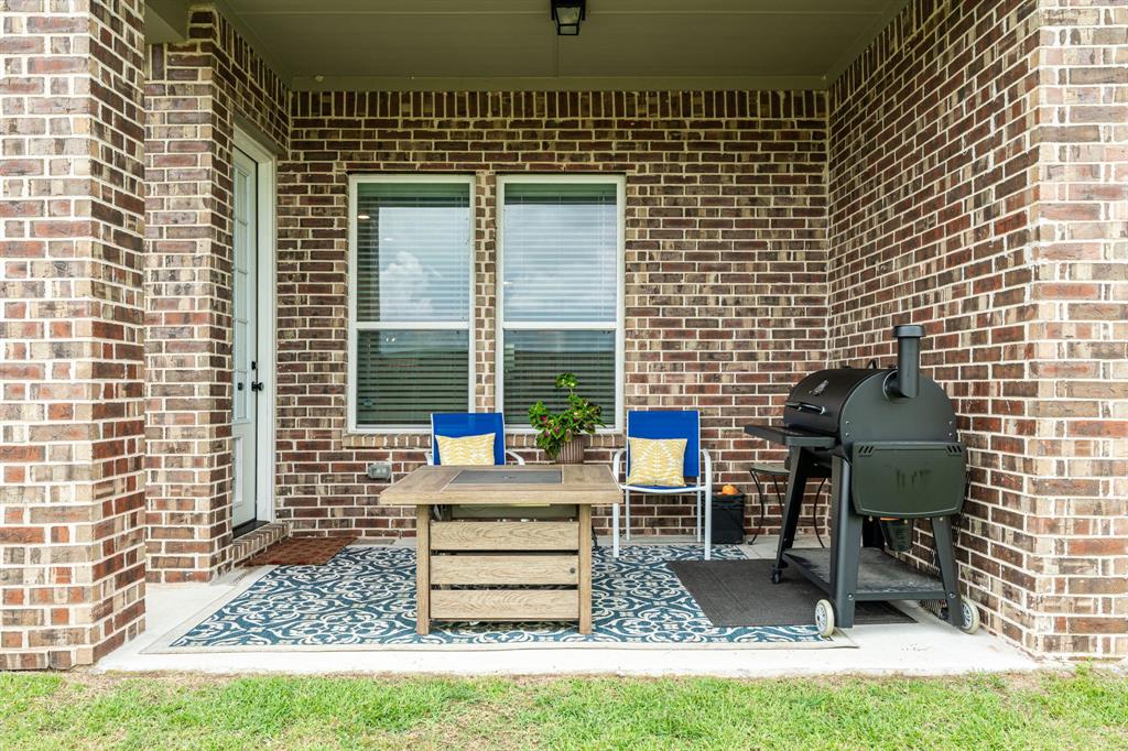 313 Tate Lane Anna, TX 75409 - Photo 27 of 30 Covered patio featuring brick exterior walls, a concrete floor, and a white exterior door