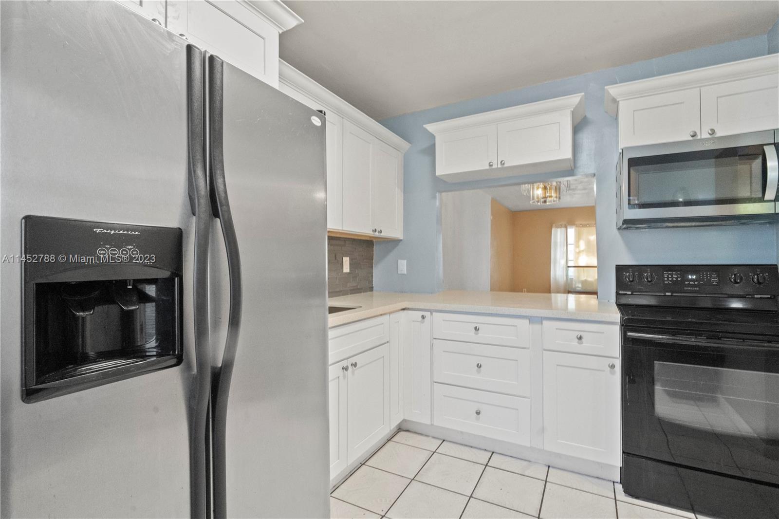Norland Miami, FL 33179 - Photo 5 of 15 a kitchen with white cabinets and stainless steel appliances