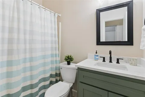 a bathroom with a sink a toilet and shower curtain