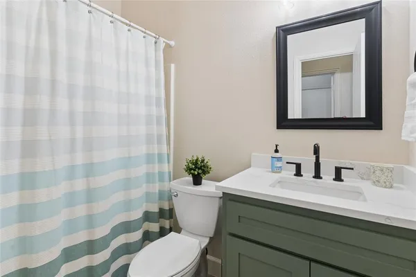 a bathroom with a sink a toilet and shower curtain