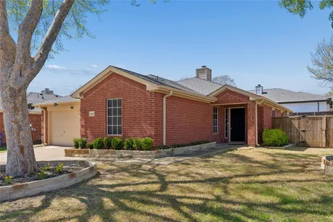 a front view of a house with a yard and potted plants