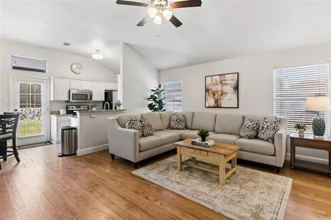 a living room with furniture a fireplace and a kitchen view