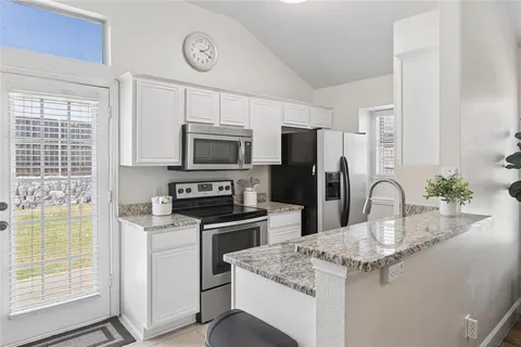 a kitchen with a sink appliances and cabinets
