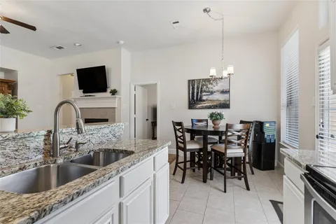 a kitchen with a dining table chairs and a potted plant