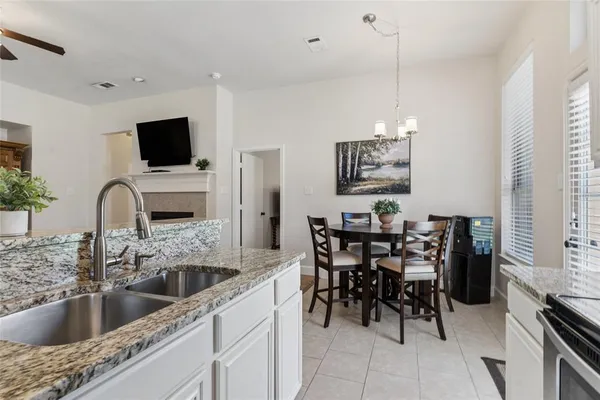 a kitchen with a dining table chairs and a potted plant