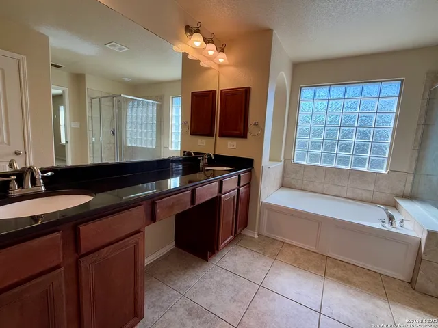 a bathroom with a tub sink and mirror