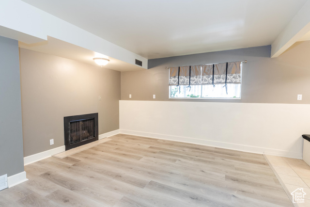 167 East 100 North, Unit B Logan, UT 84321 - Photo 2 of 18 Basement featuring a fireplace and light wood-style floors