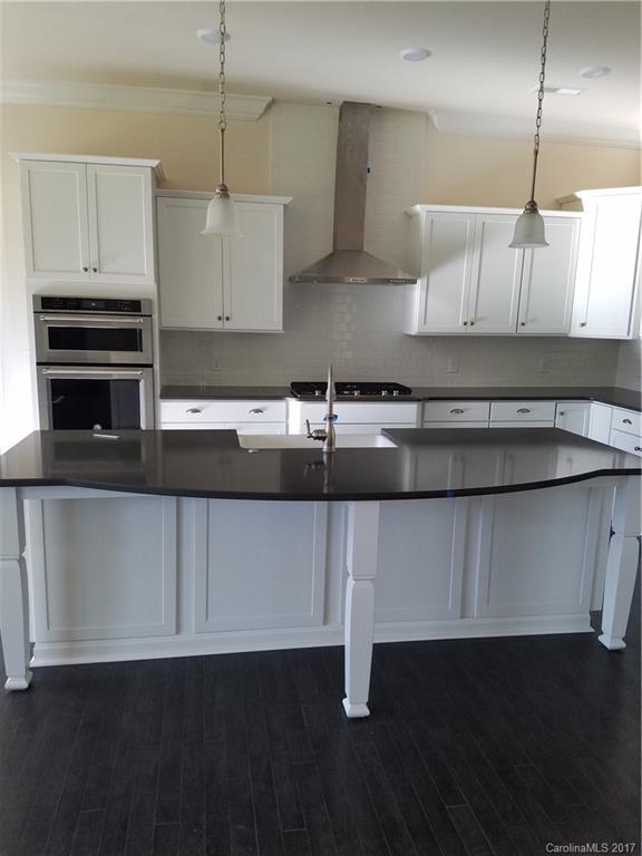 7003 Fallondale Road, Unit MB515 Waxhaw, NC 28173 - Photo 3 of 10 a kitchen with kitchen island granite countertop a sink cabinets and stainless steel appliances
