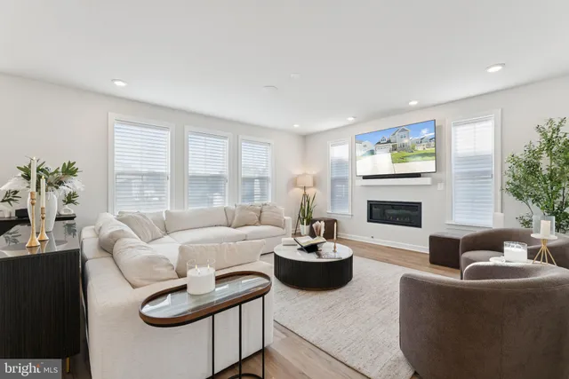 a living room with furniture and a dining table with wooden floor
