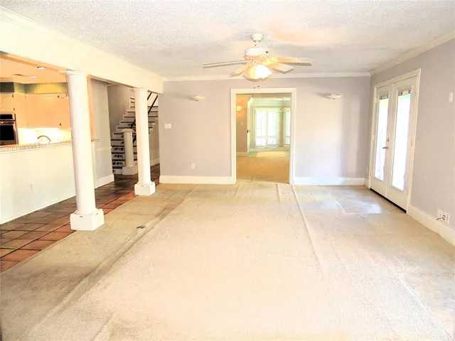a view of an empty room with window and a livingroom