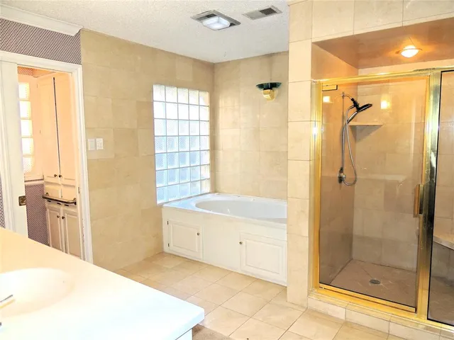 a bathroom with a bathtub a shower and a sink