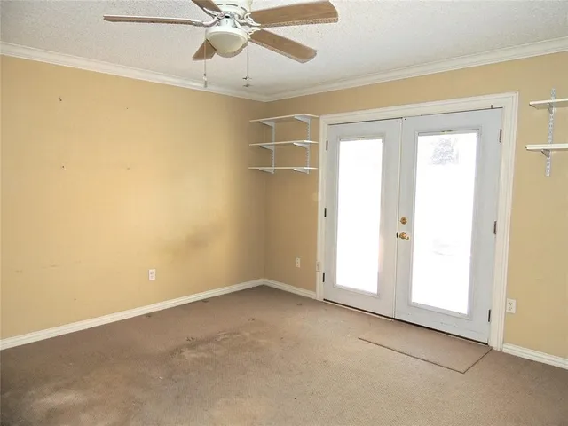 an empty room with a ceiling fan and a window