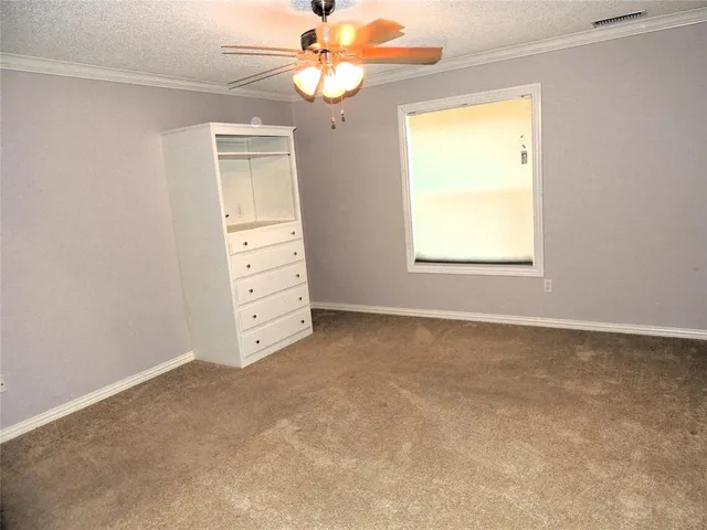 an empty room with windows and fan