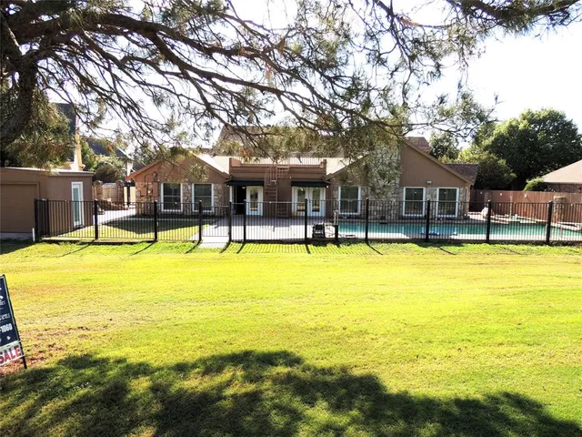 a view of a swimming pool with lawn chairs under an umbrella
