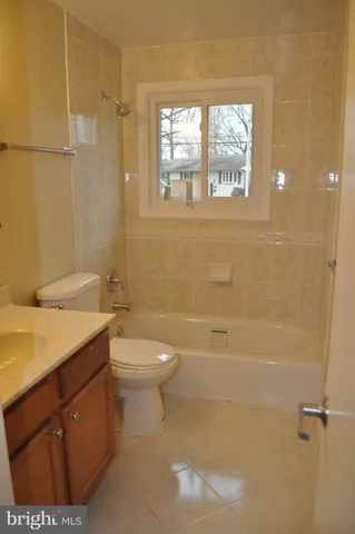 a bathroom with a granite countertop toilet a sink and a bathtub