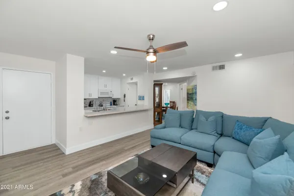 a living room with furniture and a wooden floor