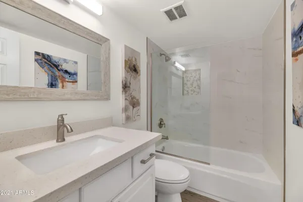 a bedroom with a bed and painting on the wall