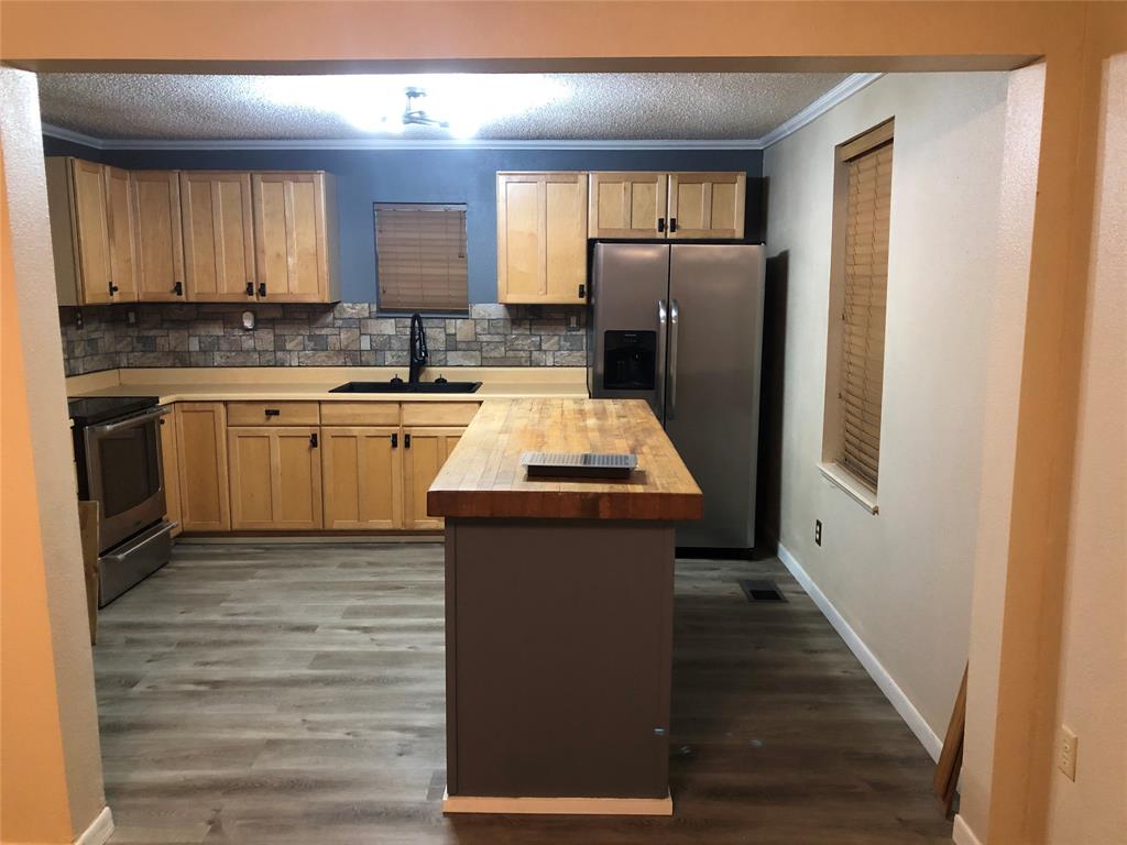 210 Jones Road Graford, TX 76449 - Photo 6 of 25 a kitchen with a refrigerator sink and cabinets