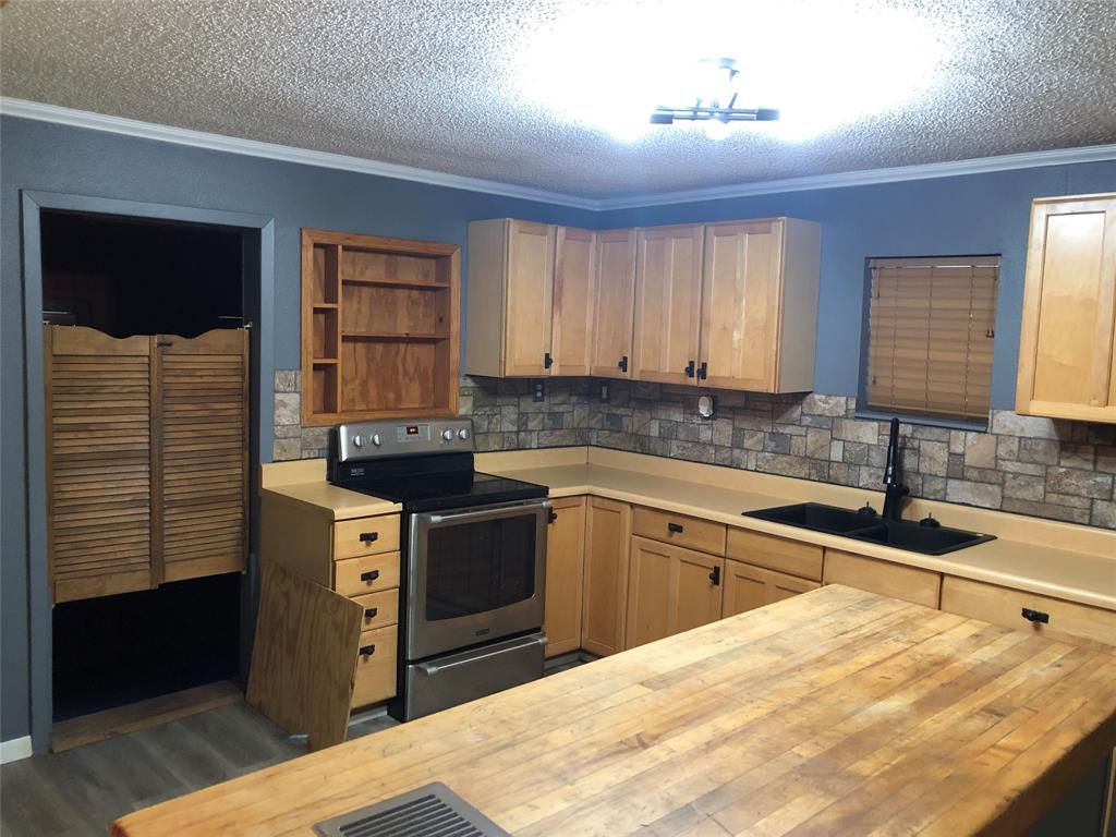210 Jones Road Graford, TX 76449 - Photo 7 of 25 a kitchen with stainless steel appliances granite countertop a sink stove and cabinets