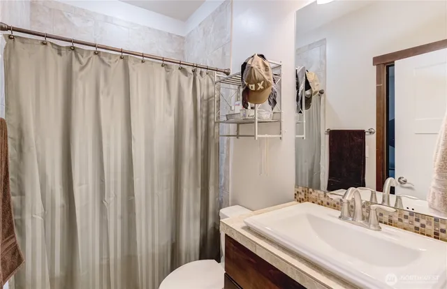 a bathroom with a sink a toilet and shower curtain
