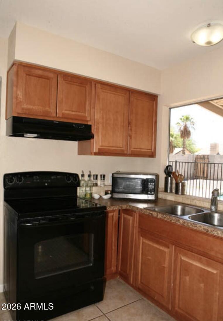 911 West Colgate Drive Tempe, AZ 85283 - Photo 6 of 15 a kitchen with granite countertop a stove top oven microwave and cabinets