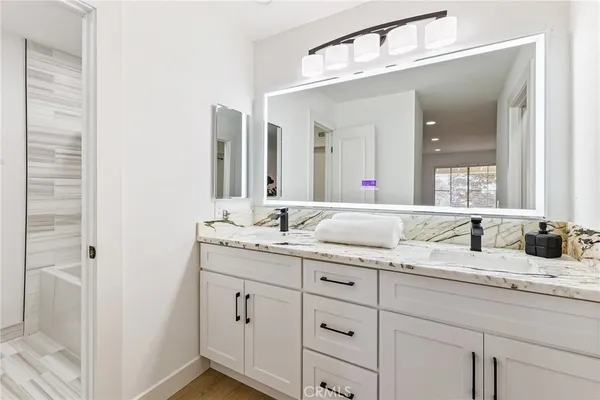 a bathroom with a granite countertop sink double and mirror